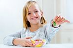 Beautiful Child Eating Sweets At Home Stock Photo